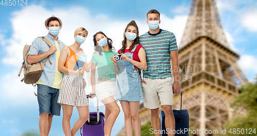 Image of friends in masks with travel bags at eiffel tower