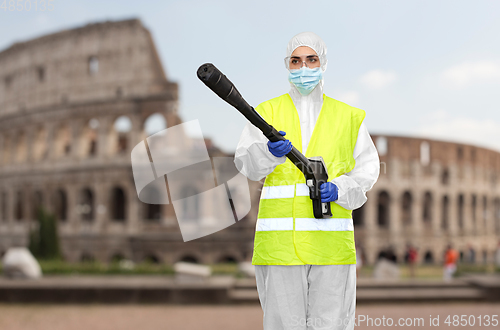 Image of sanitation worker in hazmat with pressure washer