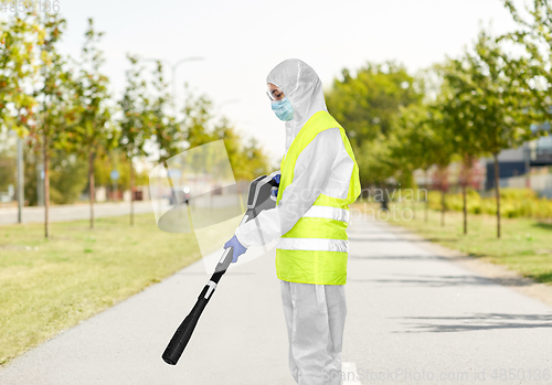 Image of sanitation worker in hazmat with pressure washer