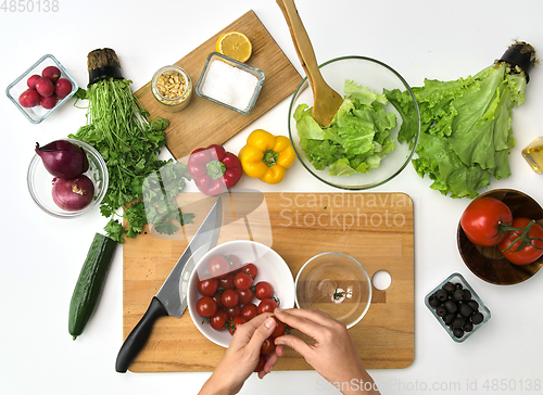 Image of woman with cherry tomatoes at kitchen