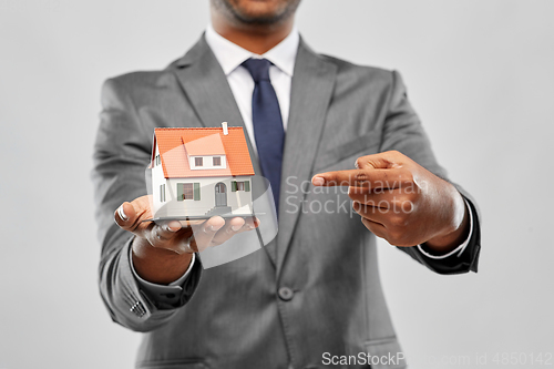 Image of indian man realtor with house model and folder