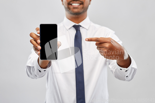 Image of smiling indian businessman showing smartphone