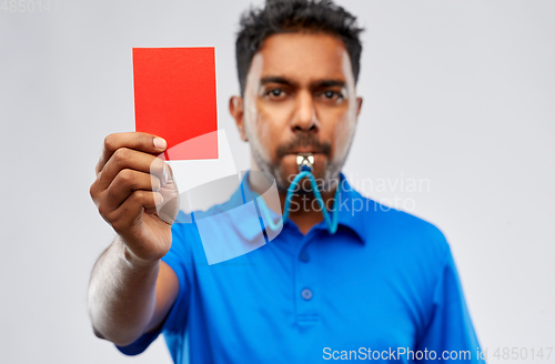 Image of indian referee whistling and showing red card