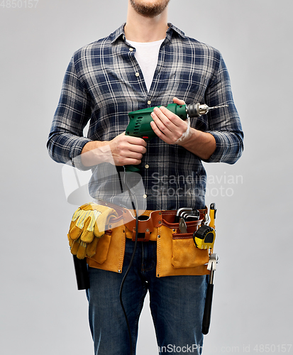 Image of male repairer or builder with drill and work tools