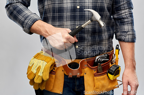 Image of male builder with hammer and working tools on belt