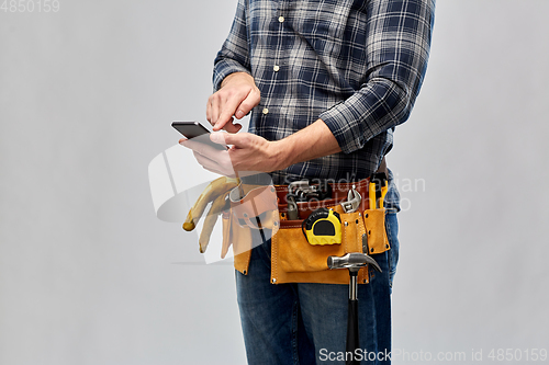 Image of worker or builder with phone and working tools