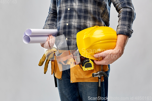 Image of builder with helmet, blueprint and working tools