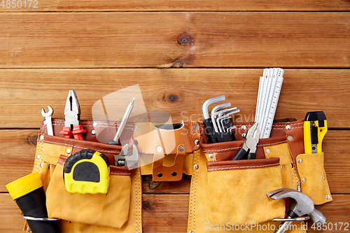 Image of different work tools in belt on wooden boards