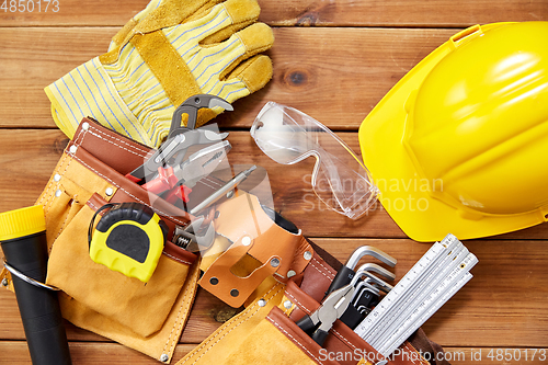 Image of different work tools in belt on wooden boards