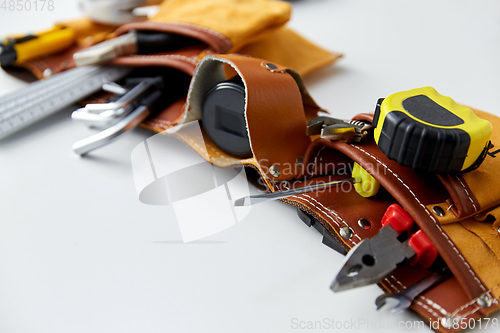 Image of different work tools in belt on white background