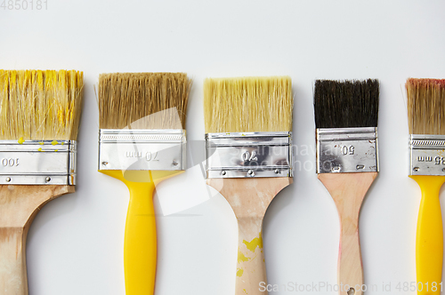 Image of different size paint brushes on white background