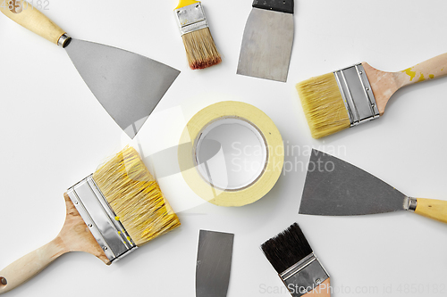 Image of different size paint brushes and putty knives