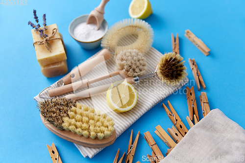 Image of cleaning brushes, lemon and wooden clothespins