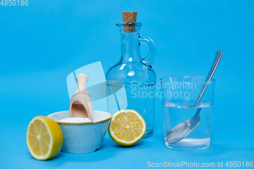 Image of lemons, washing soda, bottle of vinegar and glass