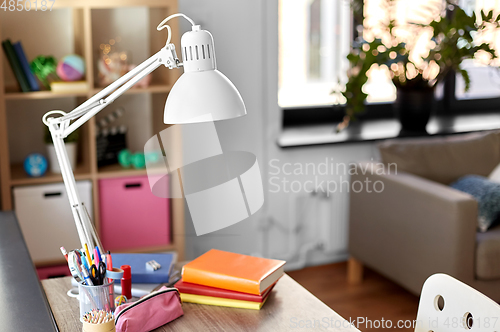 Image of room with lamp and school supplies on table