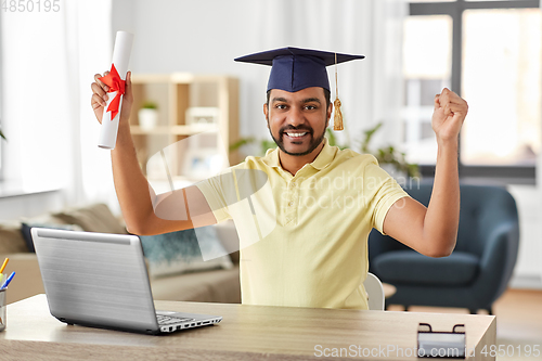 Image of indian student with laptop and diploma at home