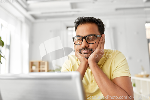 Image of bored man with laptop working at home office