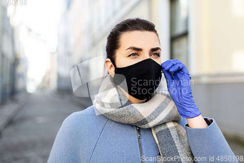 Image of woman wearing protective reusable mask in city