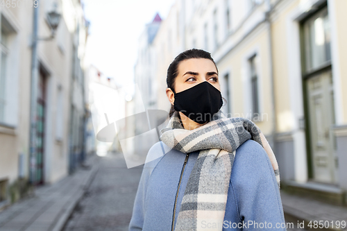 Image of woman wearing protective reusable mask in city