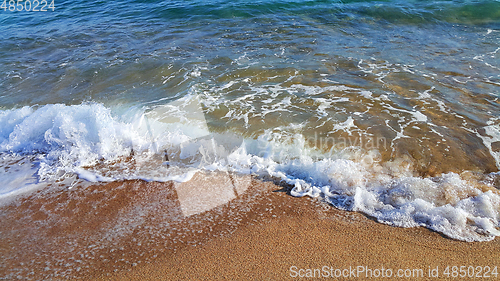 Image of Sea water with white foam on the coastal sand