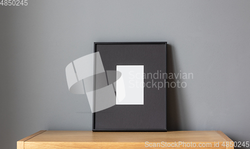 Image of empty frame on wooden shelf