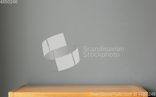 Image of wooden shelf and grey wall