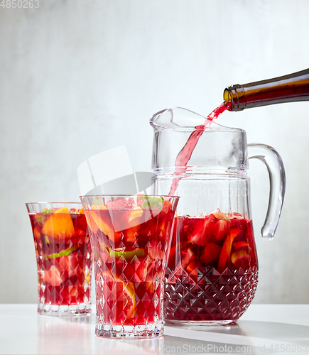 Image of red wine pouring into jug