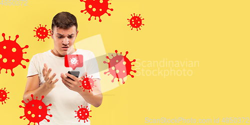 Image of Young man using phone, watching news of coronavirus spreading and worldwide cases, shocked and sad