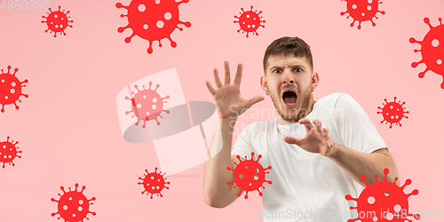 Image of Young man scared of coronavirus spreading and worldwide cases, shocked, keeping quarantine