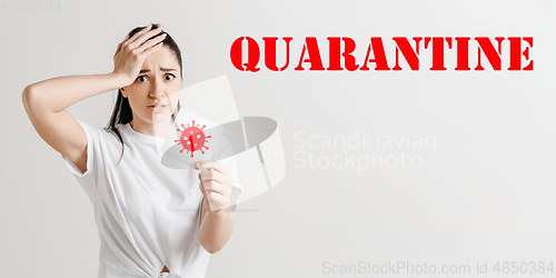 Image of Young woman scared of coronavirus spreading and worldwide cases, shocked, keeping quarantine