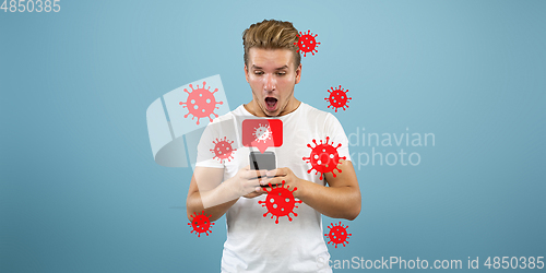 Image of Young man using phone, watching news of coronavirus spreading and worldwide cases, shocked and sad