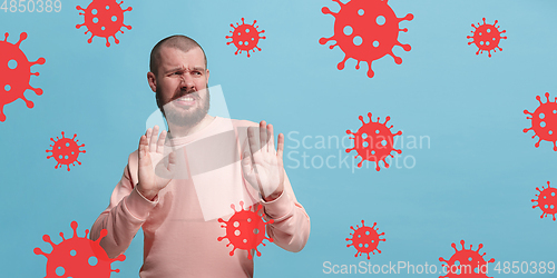 Image of Young man scared of coronavirus spreading and worldwide cases, shocked, keeping quarantine