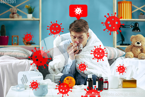 Image of Young man scared of coronavirus spreading and worldwide cases, feeling ill, sick, fever