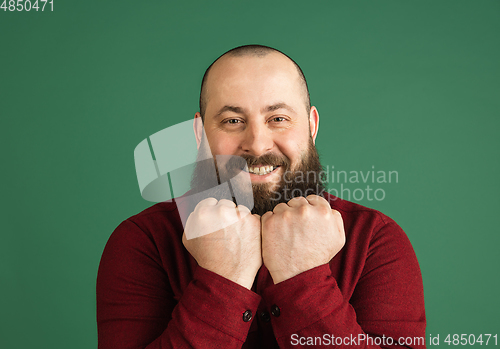 Image of Handsome caucasian man portrait isolated on green studio background with copyspace