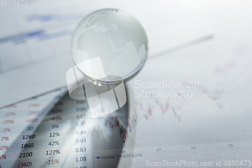 Image of Glass globe on stock market chart