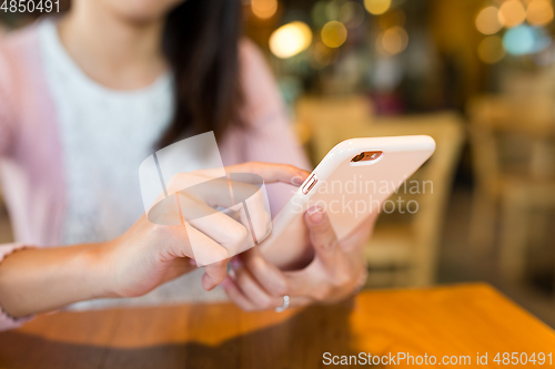Image of Woman using mobile phone in coffee shop