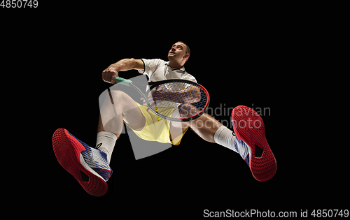 Image of Young caucasian tennis player in action, motion isolated on black background, look from the bottom. Concept of sport, movement, energy and dynamic.