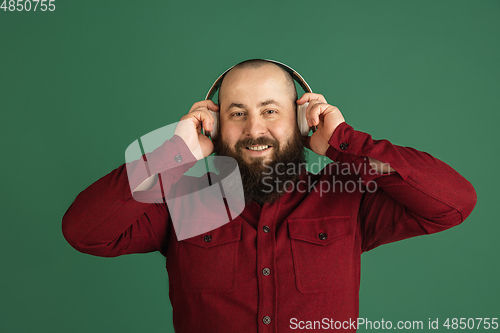 Image of Handsome caucasian man portrait isolated on green studio background with copyspace