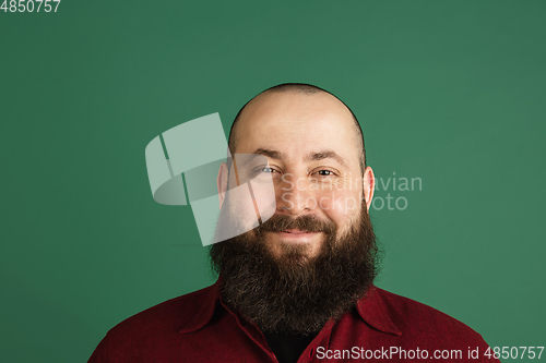 Image of Handsome caucasian man portrait isolated on green studio background with copyspace