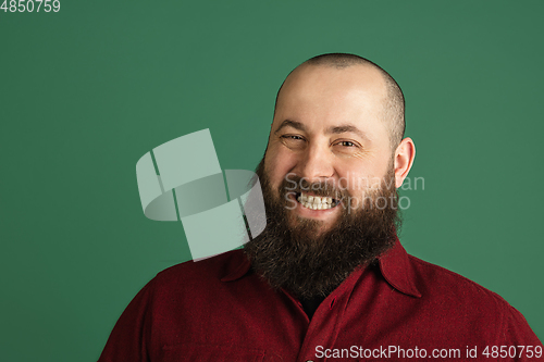 Image of Handsome caucasian man portrait isolated on green studio background with copyspace