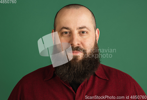 Image of Handsome caucasian man portrait isolated on green studio background with copyspace