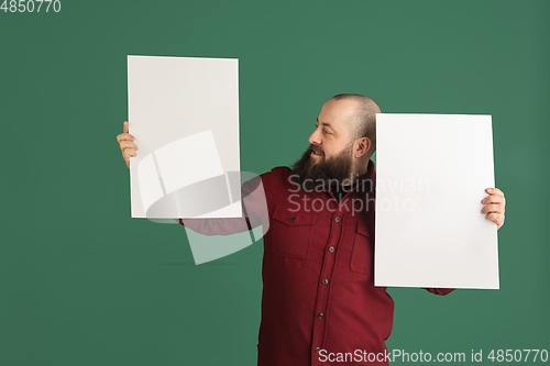 Image of Handsome caucasian man portrait isolated on green studio background with copyspace