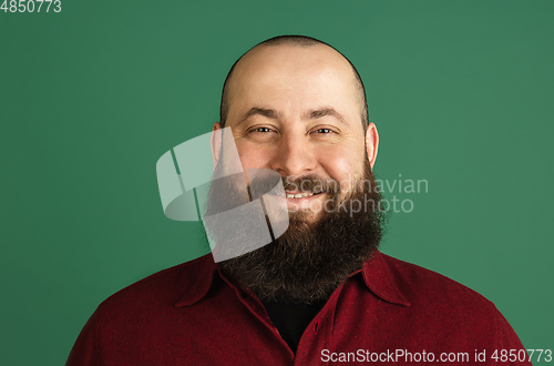 Image of Handsome caucasian man portrait isolated on green studio background with copyspace