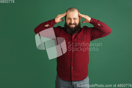 Image of Handsome caucasian man portrait isolated on green studio background with copyspace