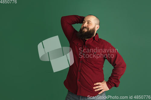 Image of Handsome caucasian man portrait isolated on green studio background with copyspace