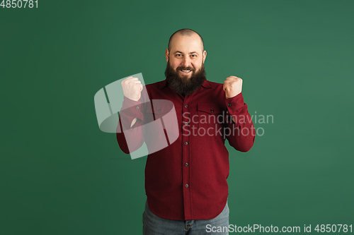 Image of Handsome caucasian man portrait isolated on green studio background with copyspace