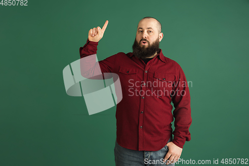 Image of Handsome caucasian man portrait isolated on green studio background with copyspace