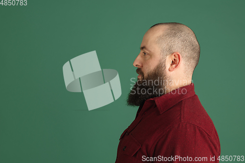 Image of Handsome caucasian man portrait isolated on green studio background with copyspace