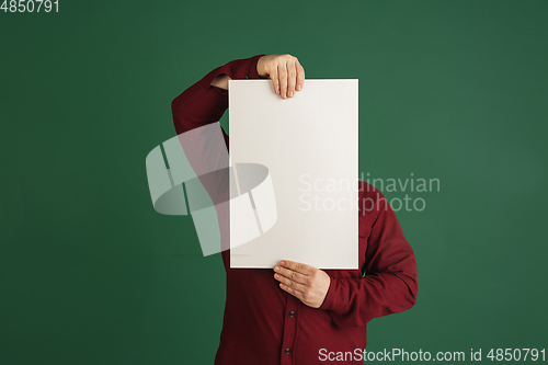 Image of Handsome caucasian man portrait isolated on green studio background with copyspace