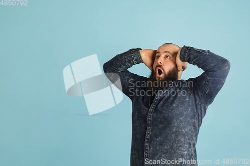 Image of Handsome caucasian man portrait isolated on blue studio background with copyspace
